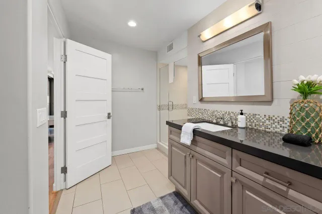 a dining room with stainless steel appliances granite countertop a dining table chairs refrigerator and a sink