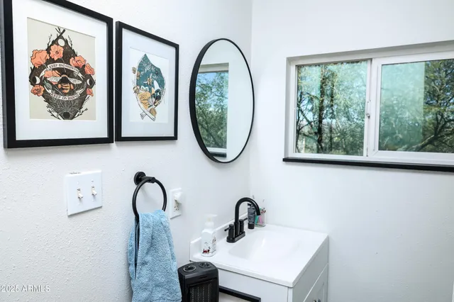 a bathroom with a sink and a painting on the wall
