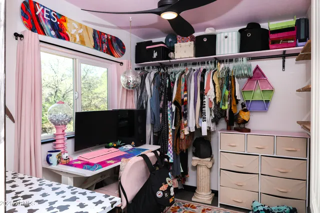 a view of walk in closet with clothes and shoes