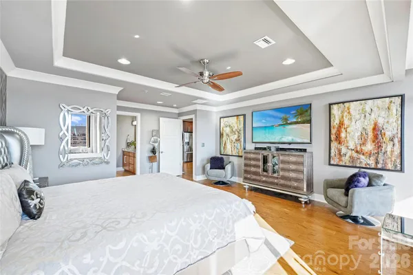 a spacious bedroom with a large bed and a flat screen tv