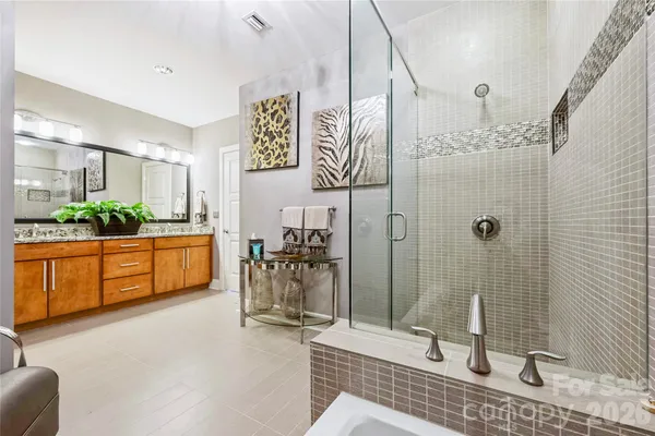 a bathroom with a double vanity sink a mirror and shower