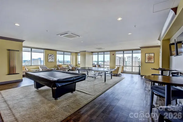 a living room with furniture a pool table and a large window