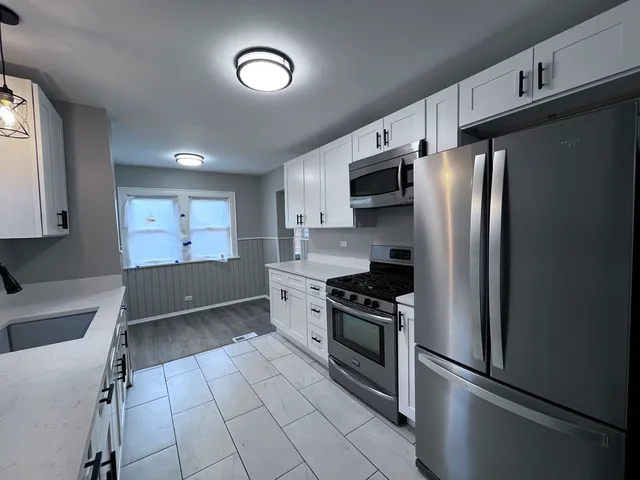 a kitchen with granite countertop a refrigerator and a sink
