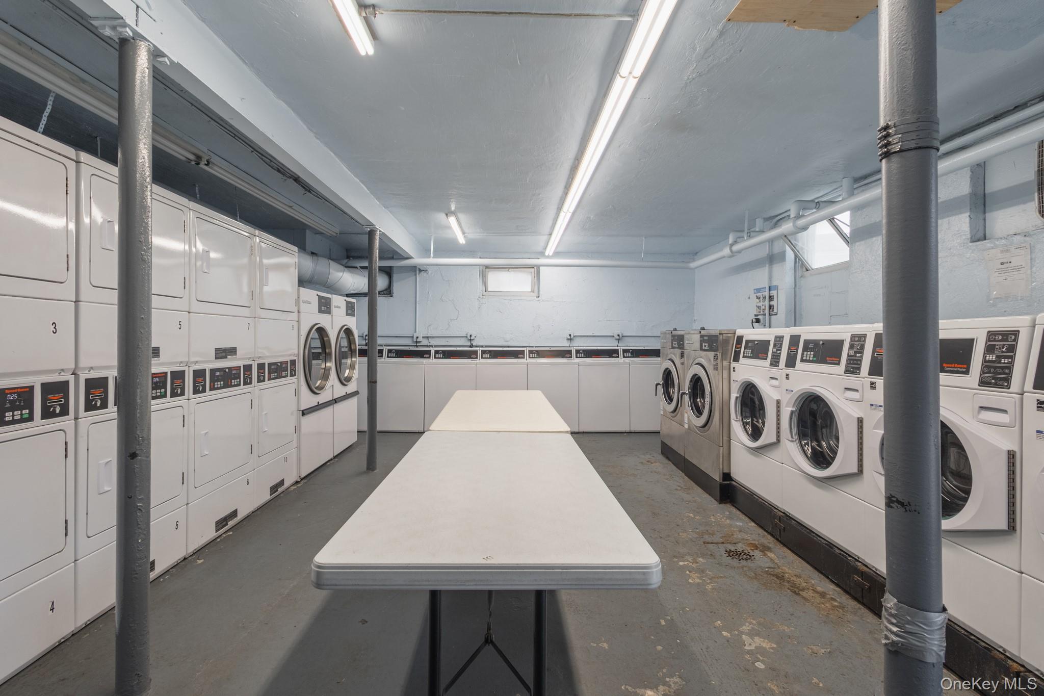 251-41 71st Road, Unit 54B Queens, NY 11426 - Photo 17 of 20 a large white kitchen with lots of appliances a sink and cabinets