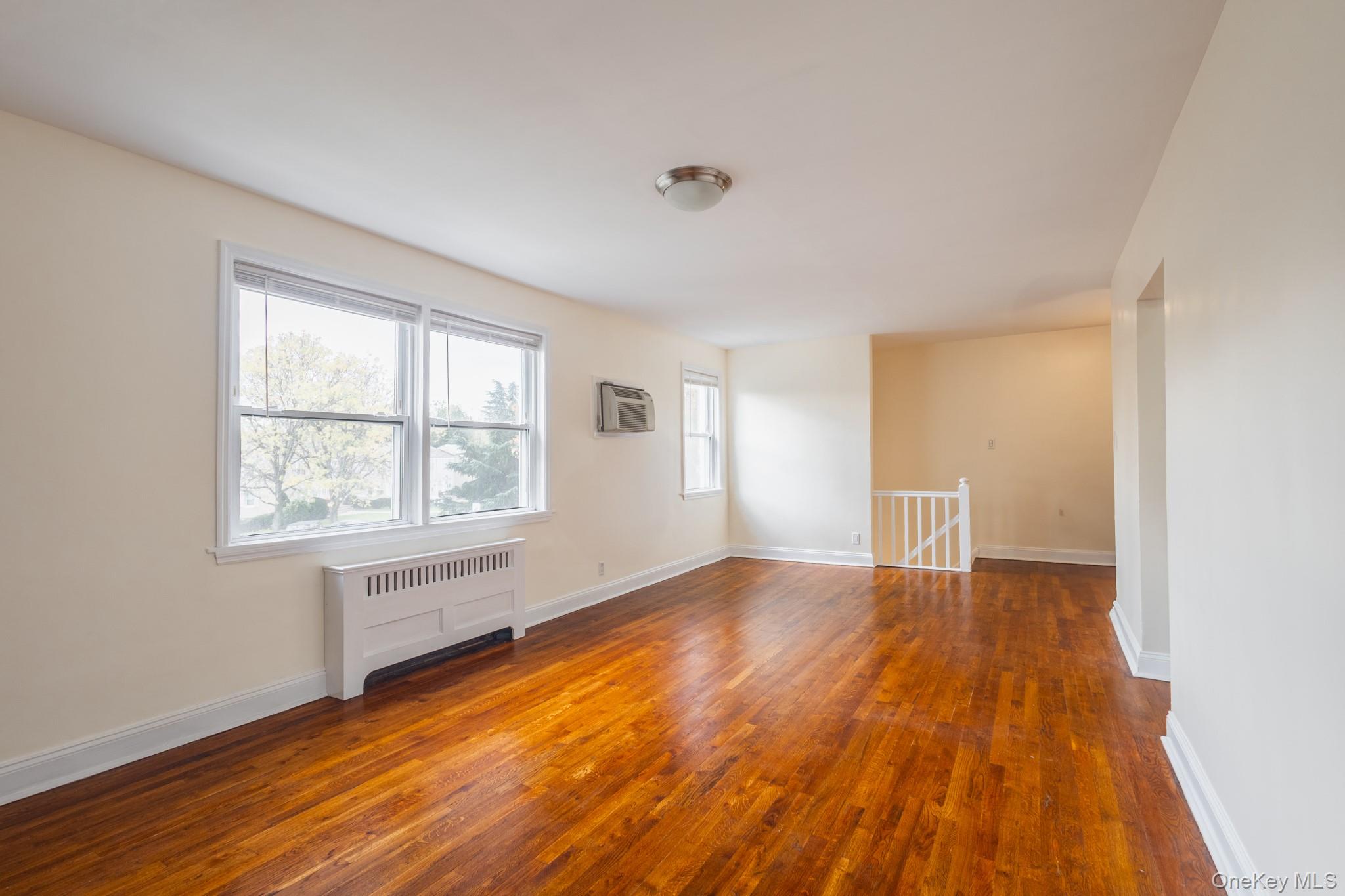 251-41 71st Road, Unit 54B Queens, NY 11426 - Photo 5 of 20 an empty room with wooden floor and windows