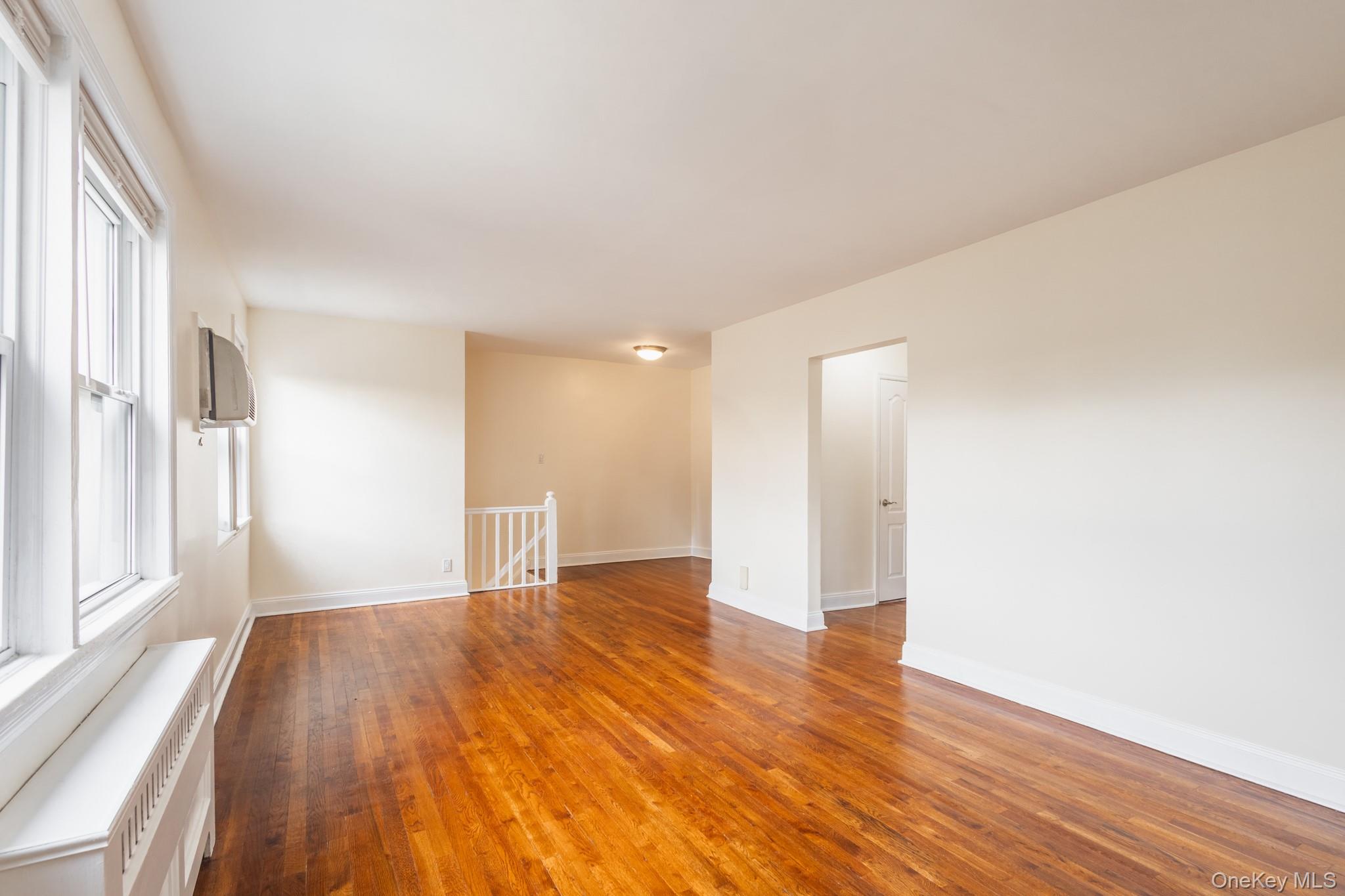 251-41 71st Road, Unit 54B Queens, NY 11426 - Photo 6 of 20 a view of an empty room with wooden floor and a window