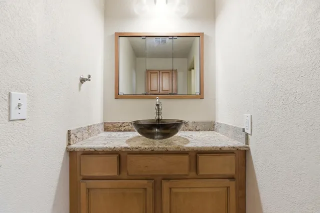 a bathroom with a granite countertop sink and a mirror