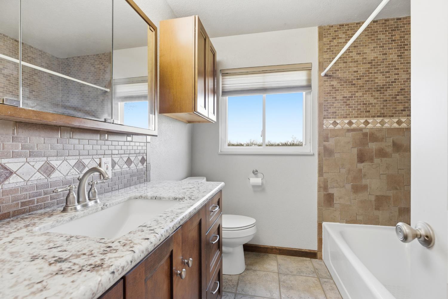 4224 Griffin Road Hughson, CA 95326 - Photo 23 of 46 a bathroom with a granite countertop sink and a bathtub