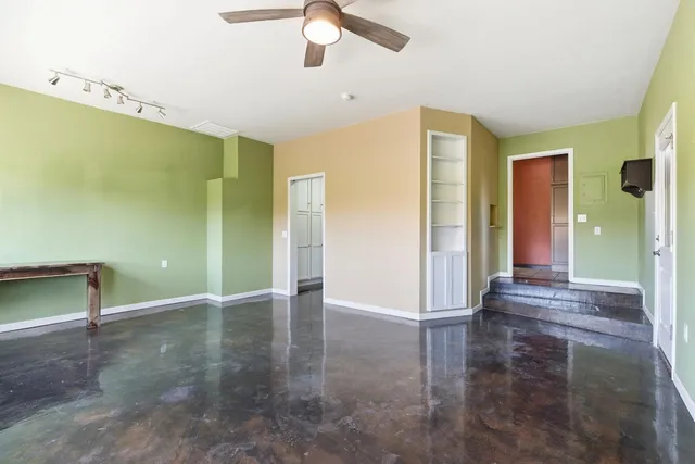 a view of a livingroom with wooden floor and a ceiling fan