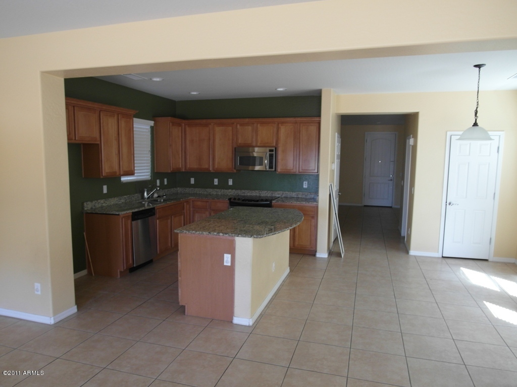 20779 West Ridge Road Buckeye, AZ 85396 - Photo 23 of 23 a kitchen with stainless steel appliances granite countertop a stove a sink and a refrigerator
