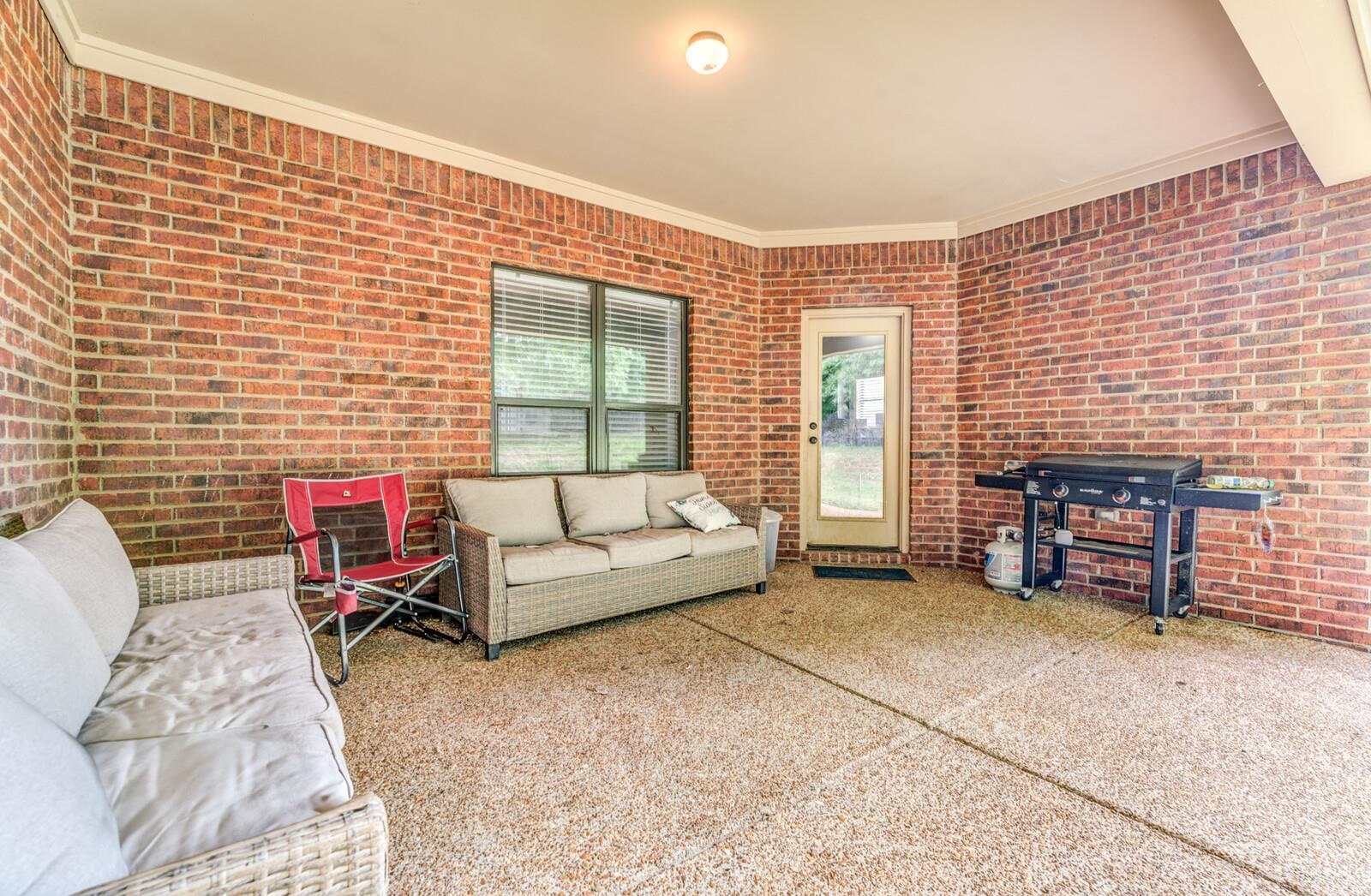 4671 Hampton Ridge Lane Bartlett, TN 38002 - Photo 32 of 40 Covered patio featuring a textured concrete floor and brick walls