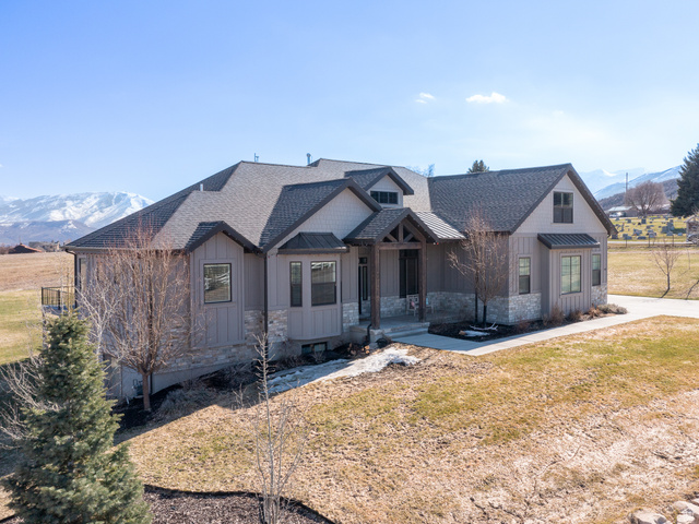 641 West 500 South Midway, UT 84049 - Photo 2 of 52 Contemporary residence featuring a covered entry, stone and vertical siding exterior, black-framed windows, a dark shingle roof, and a concrete driveway