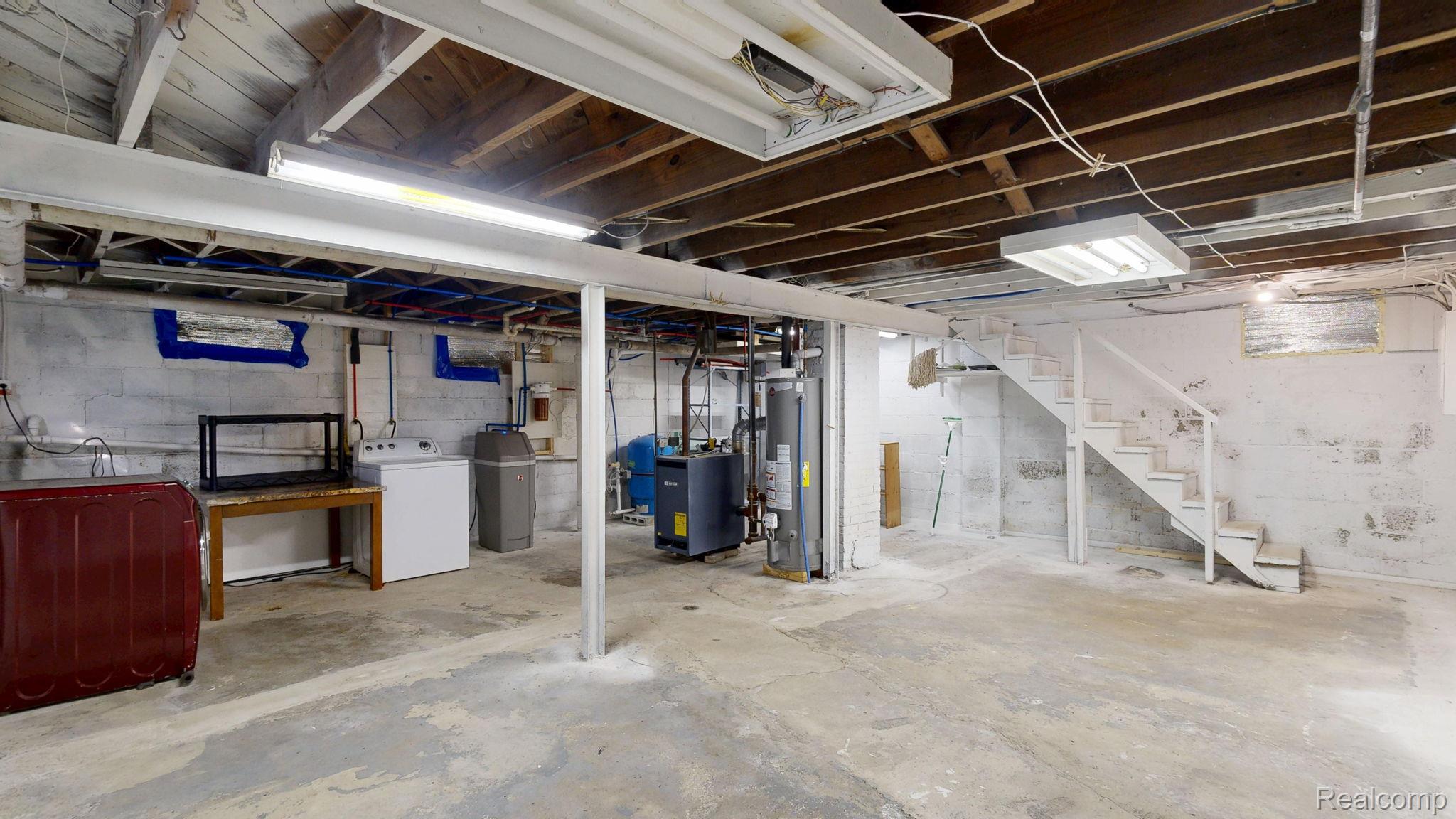 4455 North Genesee Road Flint, MI 48506 - Photo 23 of 47 Unfinished basement featuring washer / dryer, stairway, water heater, a water pressure tank, and a heating unit