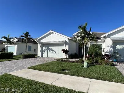 a front view of a house with a yard and potted plants