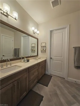 a bathroom with a double vanity sink and a mirror