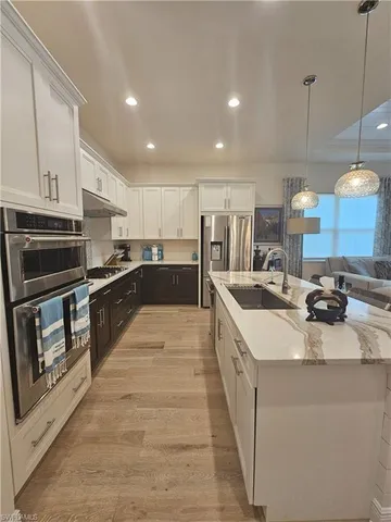 a kitchen with stainless steel appliances kitchen island granite countertop a stove and a sink