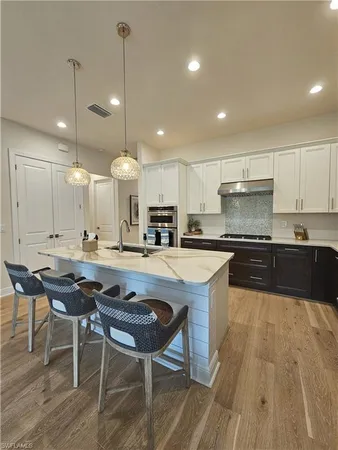 a kitchen with stainless steel appliances kitchen island granite countertop a stove and a sink