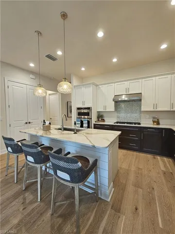 a kitchen with a dining table chairs and large window