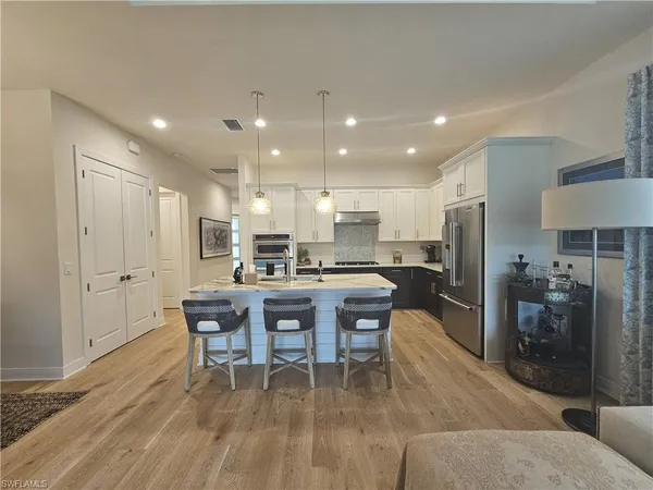 a kitchen with granite countertop a table chairs a sink dishwasher window and cabinets