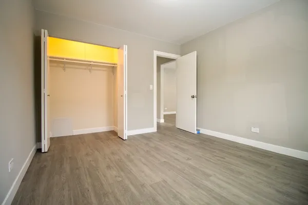 an empty room with wooden floor and closet