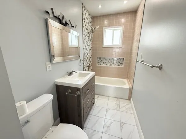 a bathroom with a sink a toilet a mirror a vanity and shower