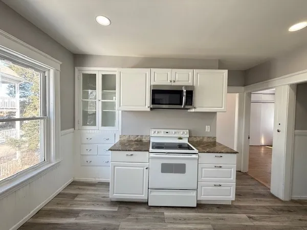 a kitchen with stainless steel appliances white cabinets and a stove top oven