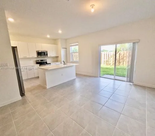 a kitchen with stainless steel appliances a sink a stove a refrigerator a window