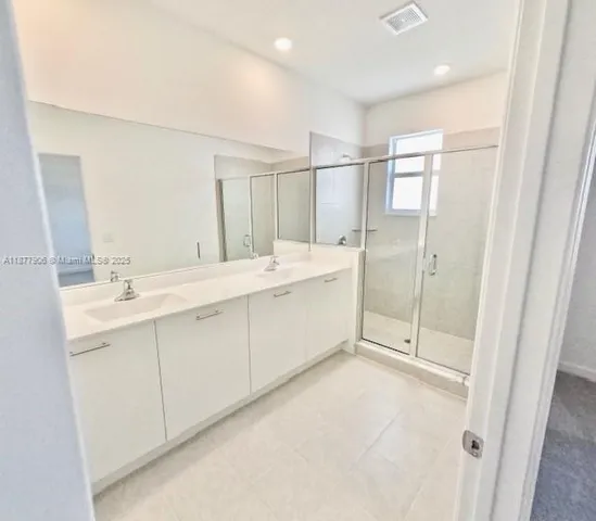 a spacious bathroom with a double vanity sink mirror and double