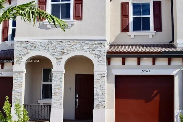 a front view of a house with plants