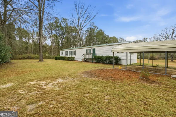 a view of house with yard outdoor seating and barbeque oven