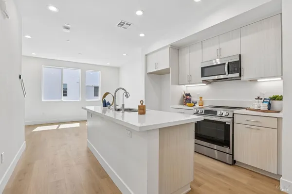 a kitchen with stainless steel appliances a sink stove and cabinets