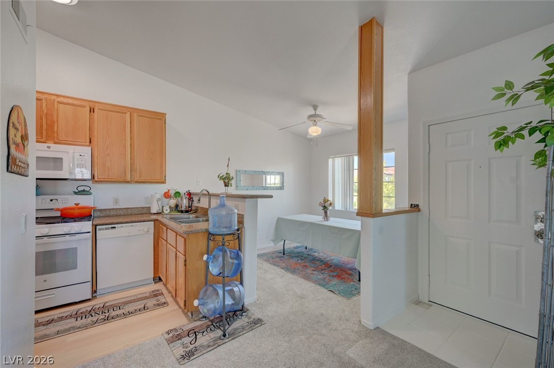 3318 North Decatur Boulevard, Unit 2072 Las Vegas, NV 89130 - Photo 14 of 50 A well-lit kitchen flows seamlessly into a dining area, offering an inviting space for daily living.