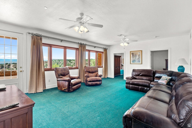 5615 East Eight Mile Gap Road Kanab, UT 84741 - Photo 55 of 81 Living area featuring carpet flooring, ceiling fan, and a textured ceiling