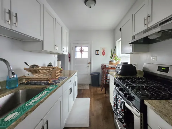 a kitchen with stainless steel appliances granite countertop a sink stove and cabinets