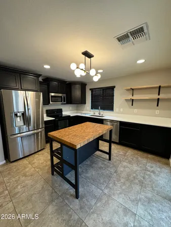 a living room with stainless steel appliances kitchen island furniture and a kitchen view