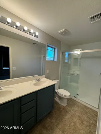 a bathroom with a sink a toilet a mirror and shower