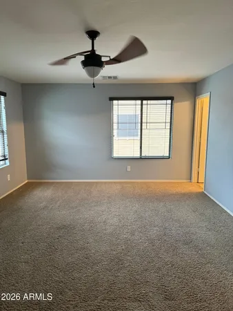 an empty room with windows and fan