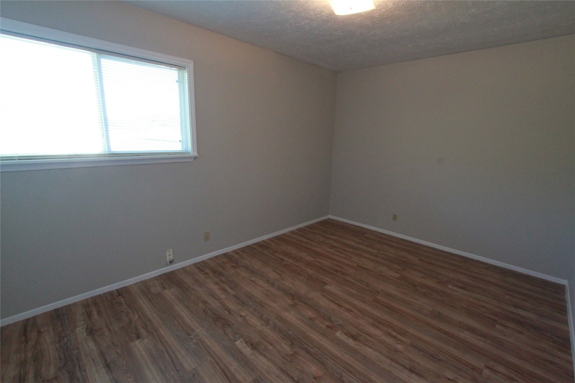 3904 Hudson Bend Road, Unit D Austin, TX 78734 - Photo 21 of 25 Unfurnished room with dark wood-style flooring and a textured ceiling