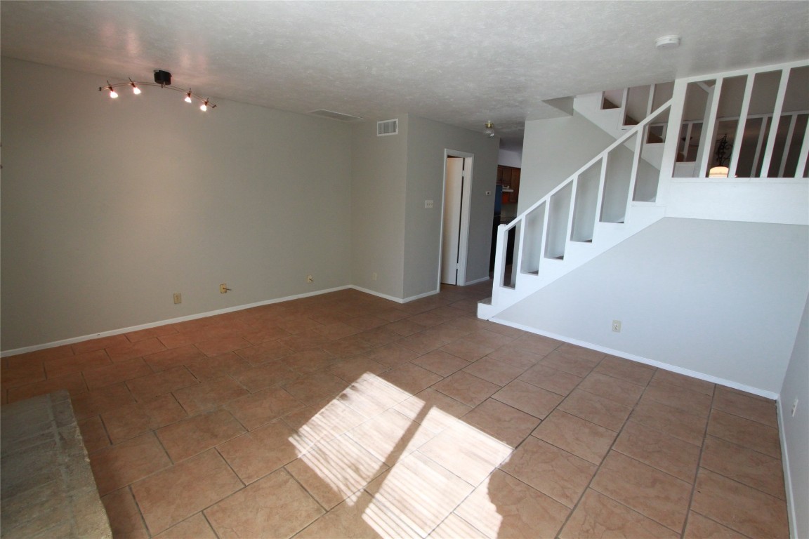 3904 Hudson Bend Road, Unit D Austin, TX 78734 - Photo 9 of 25 Unfurnished living room featuring stairs and tile patterned floors