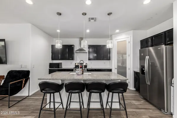 a kitchen with a dining table chairs refrigerator and microwave