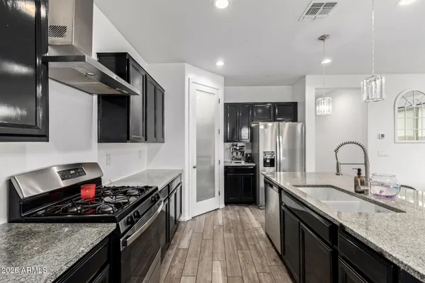 a kitchen with stainless steel appliances granite countertop a stove a sink and a refrigerator