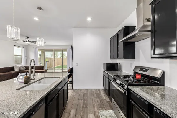 a kitchen with stainless steel appliances granite countertop a sink stove and refrigerator