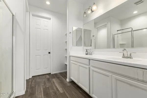 a bathroom with a double vanity sink a mirror and a shower
