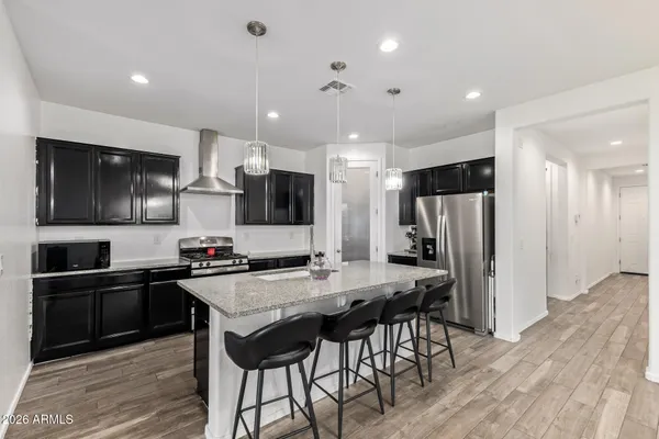 a kitchen with stainless steel appliances a stove a sink a microwave a refrigerator and cabinets