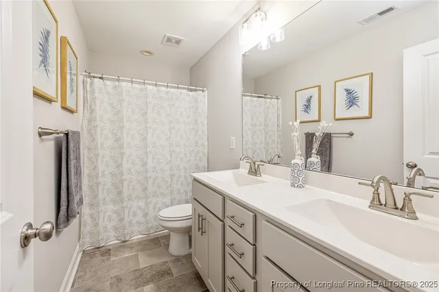 a bathroom with a double vanity sink toilet and shower