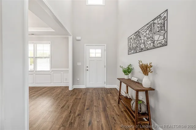 a view of a hallway with wooden floor and a potted plant