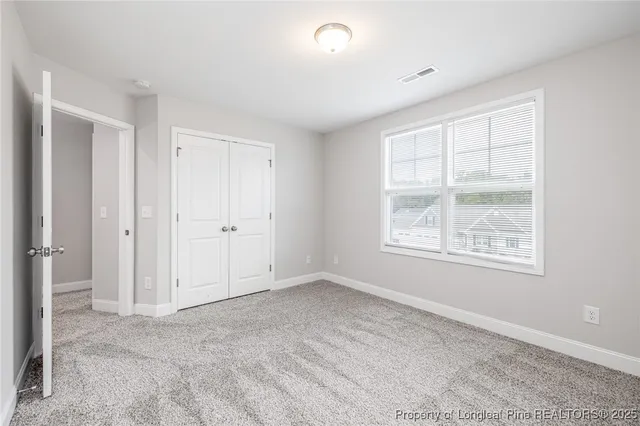 an empty room with windows and closet