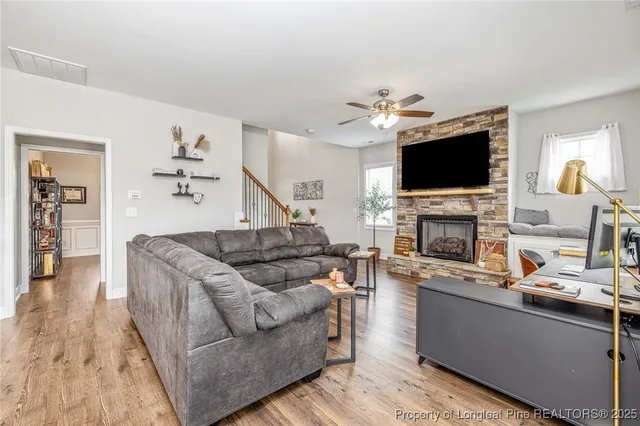 a living room with furniture a flat screen tv and a fireplace