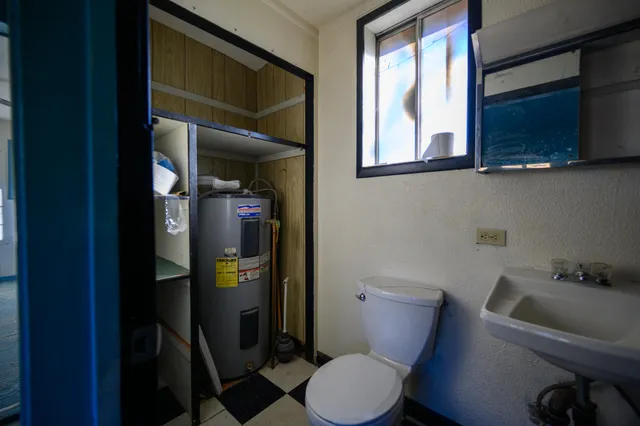 a bathroom with a toilet sink and mirror
