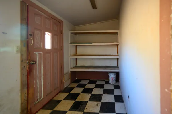 a room with a black white checkered floor and a window
